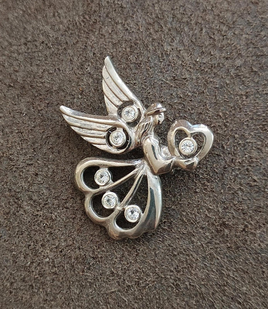 Silver angel pin with wing and heart rhinestone details on fabric