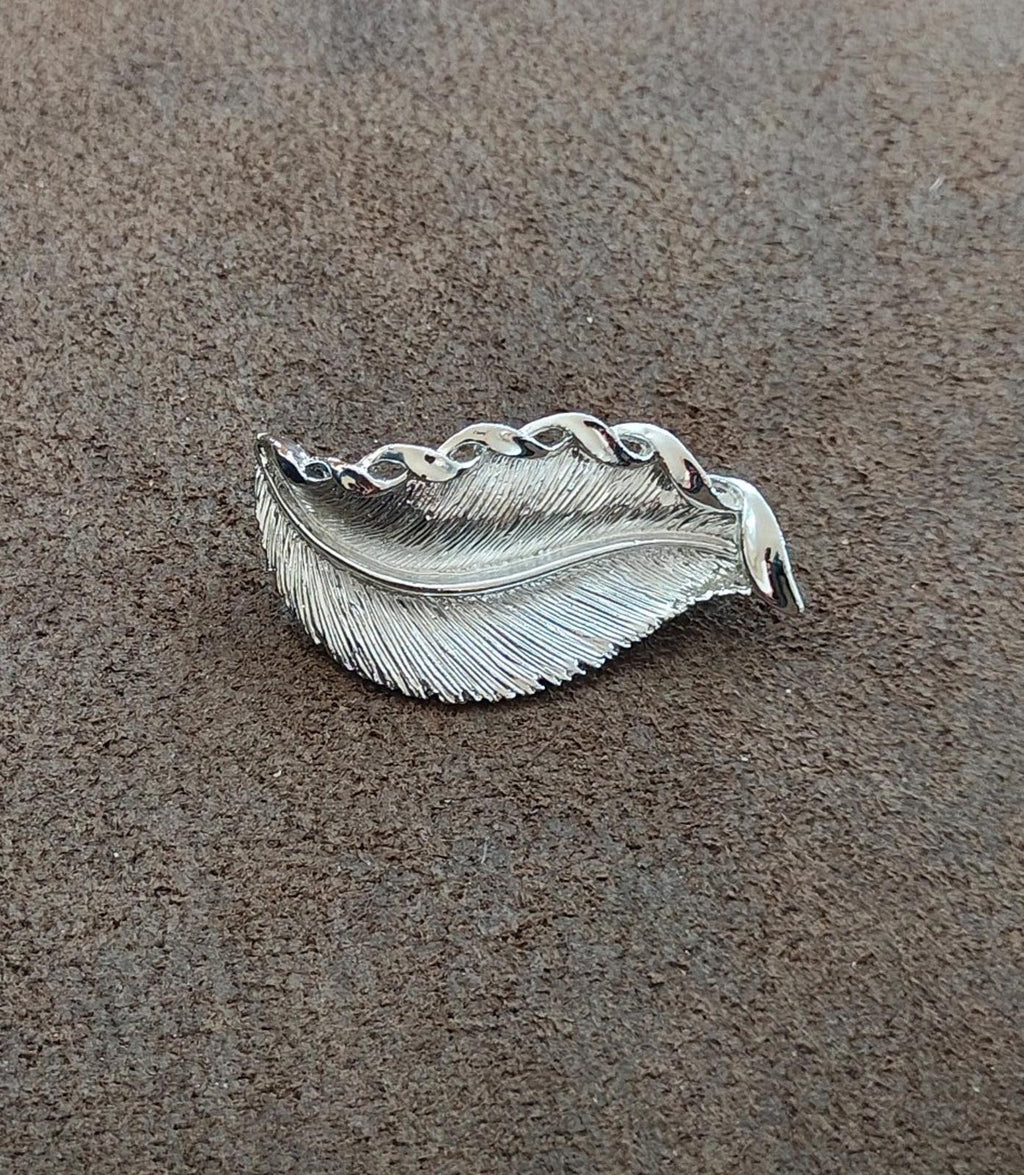 Silver tone feather/leaf brooch, side view with red stones and ribbed texture