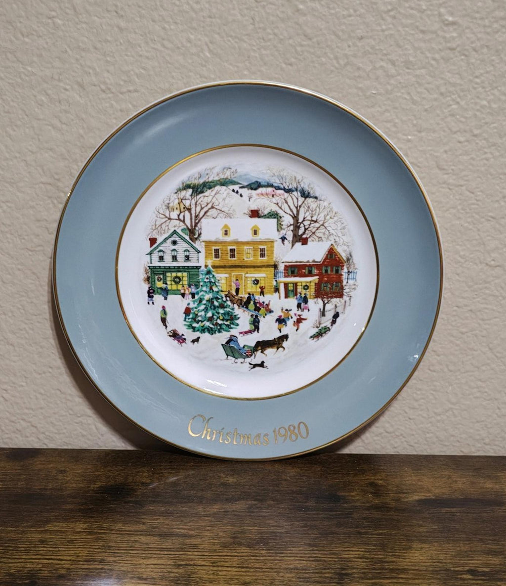 Light blue Avon Country Christmas porcelain plate with 1980 winter village scene, gold rim