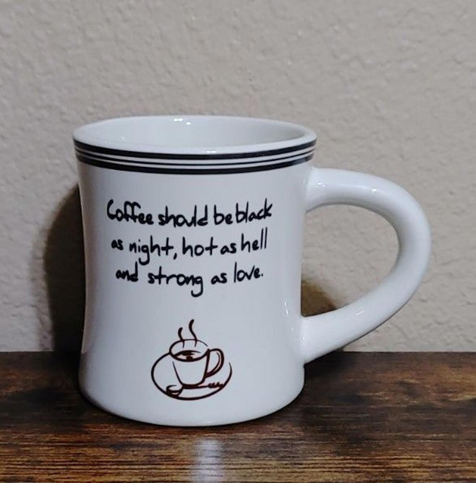 White coffee mug front view with black quote and coffee cup logo