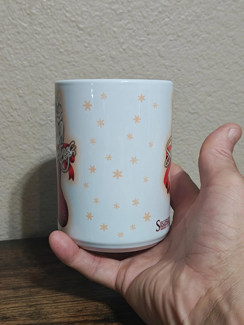 White porcelain mug side view with small gold star pattern and red ribbon accents