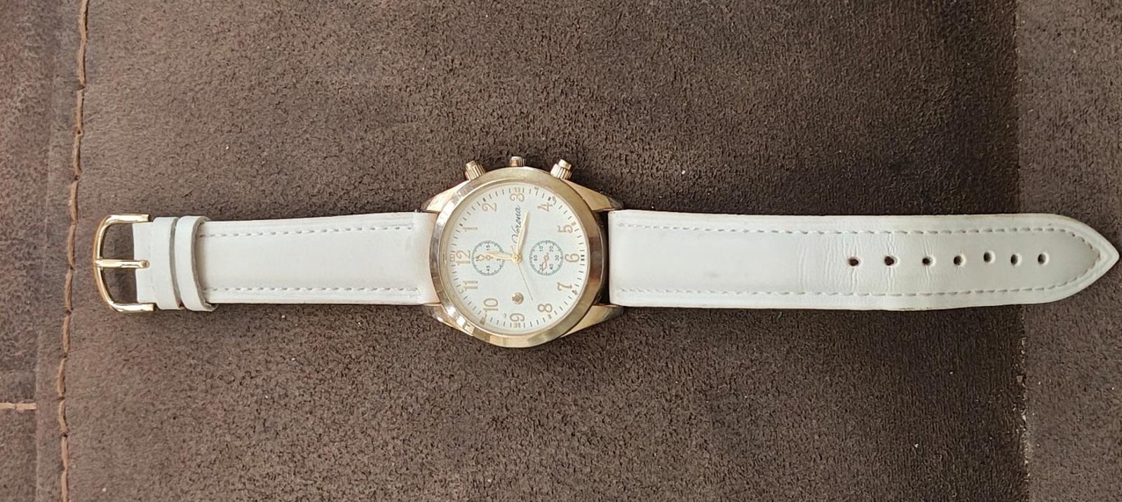 Ladies quartz watch with white leather strap, gold-tone case, and white dial front