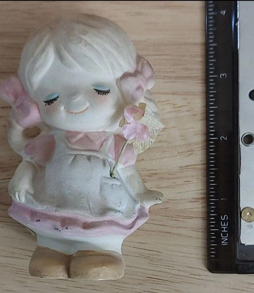 Vintage girl stoneware figurine, pink dress and bonnet, shown next to inch ruler