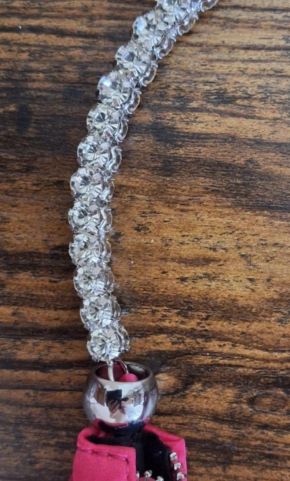 Rhinestone beaded handle with shiny charm connector on a pink satin handbag