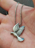 Silver-tone dove pendant with wing details on a twisted link chain
