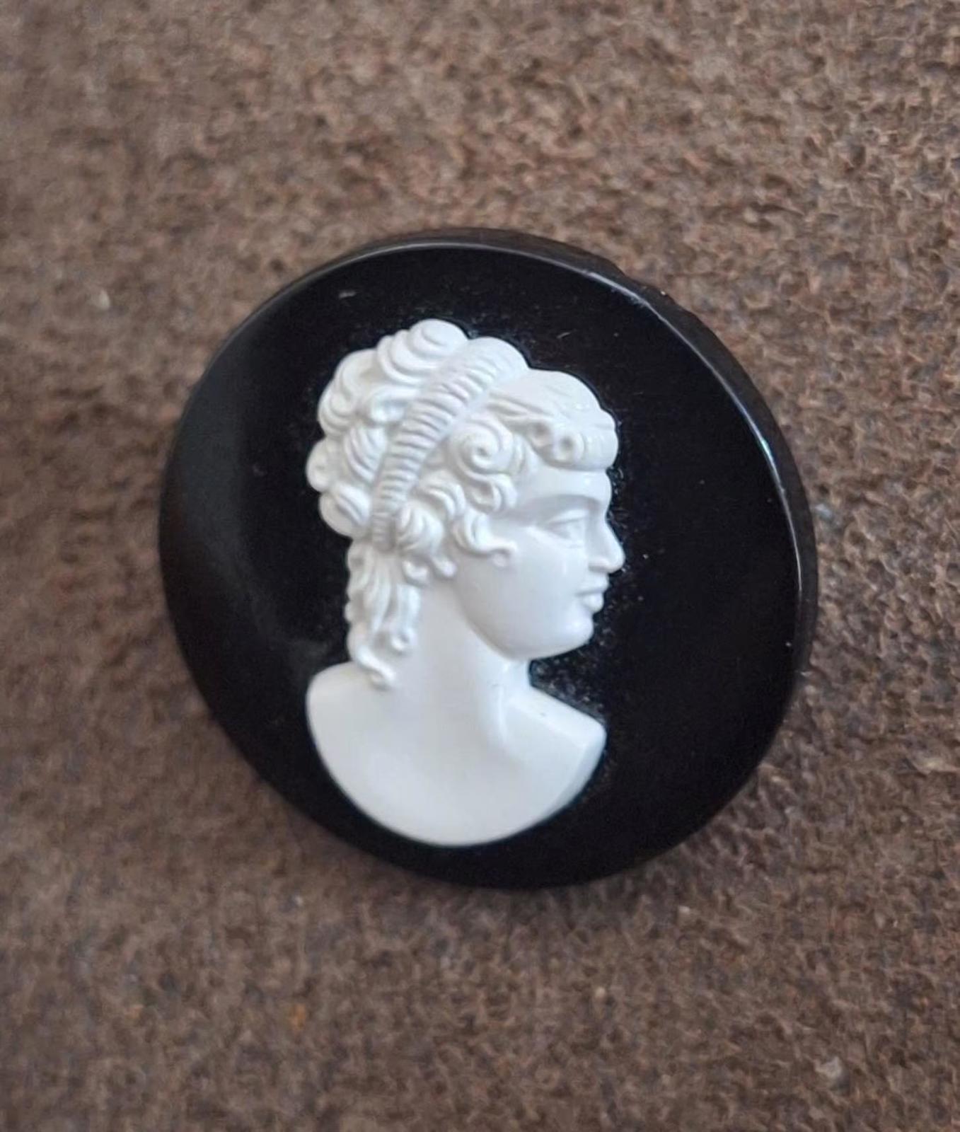 Black round cameo brooch with white woman profile head relief on black backing