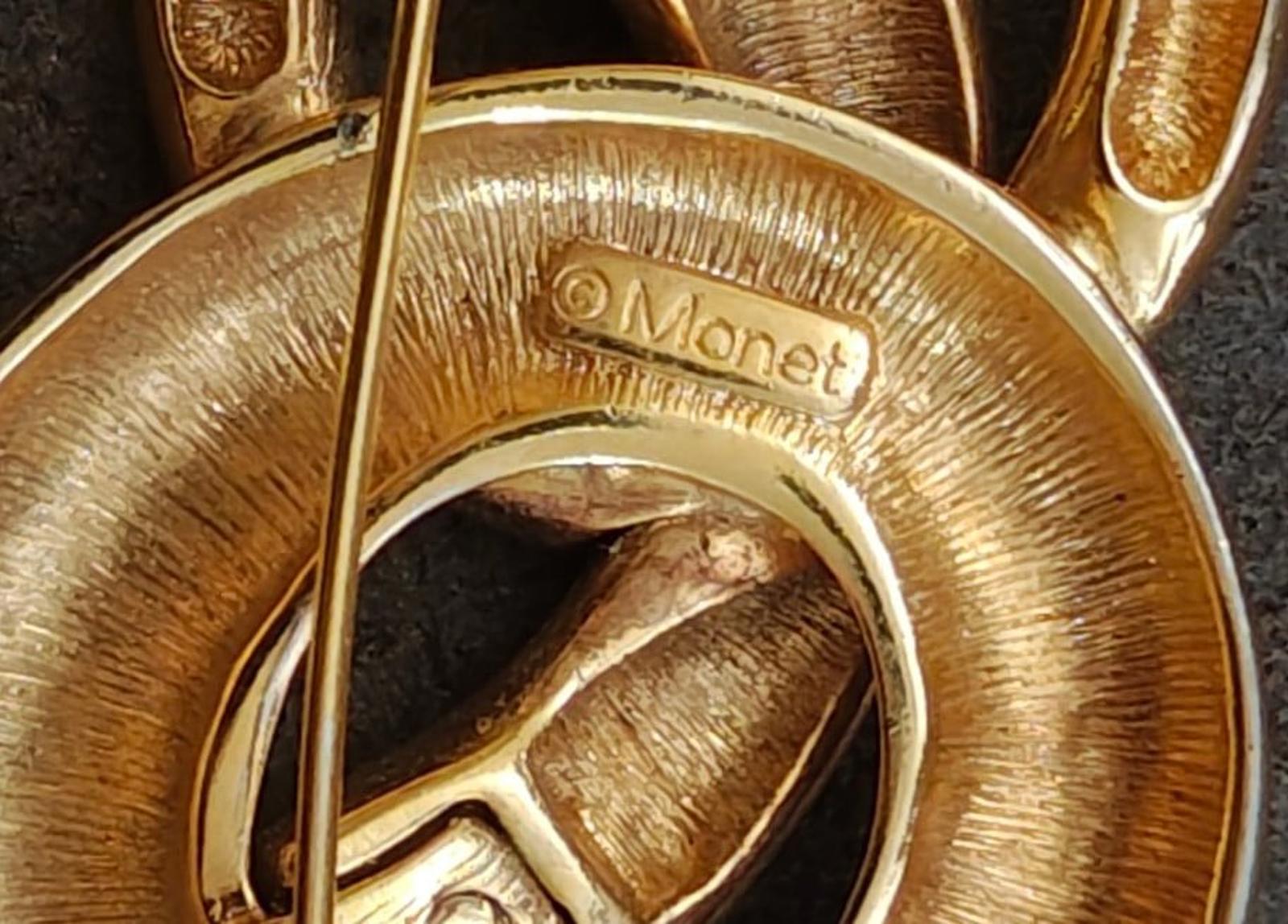Monet gold-tone pin brooch close-up showing 'Monet' hallmark