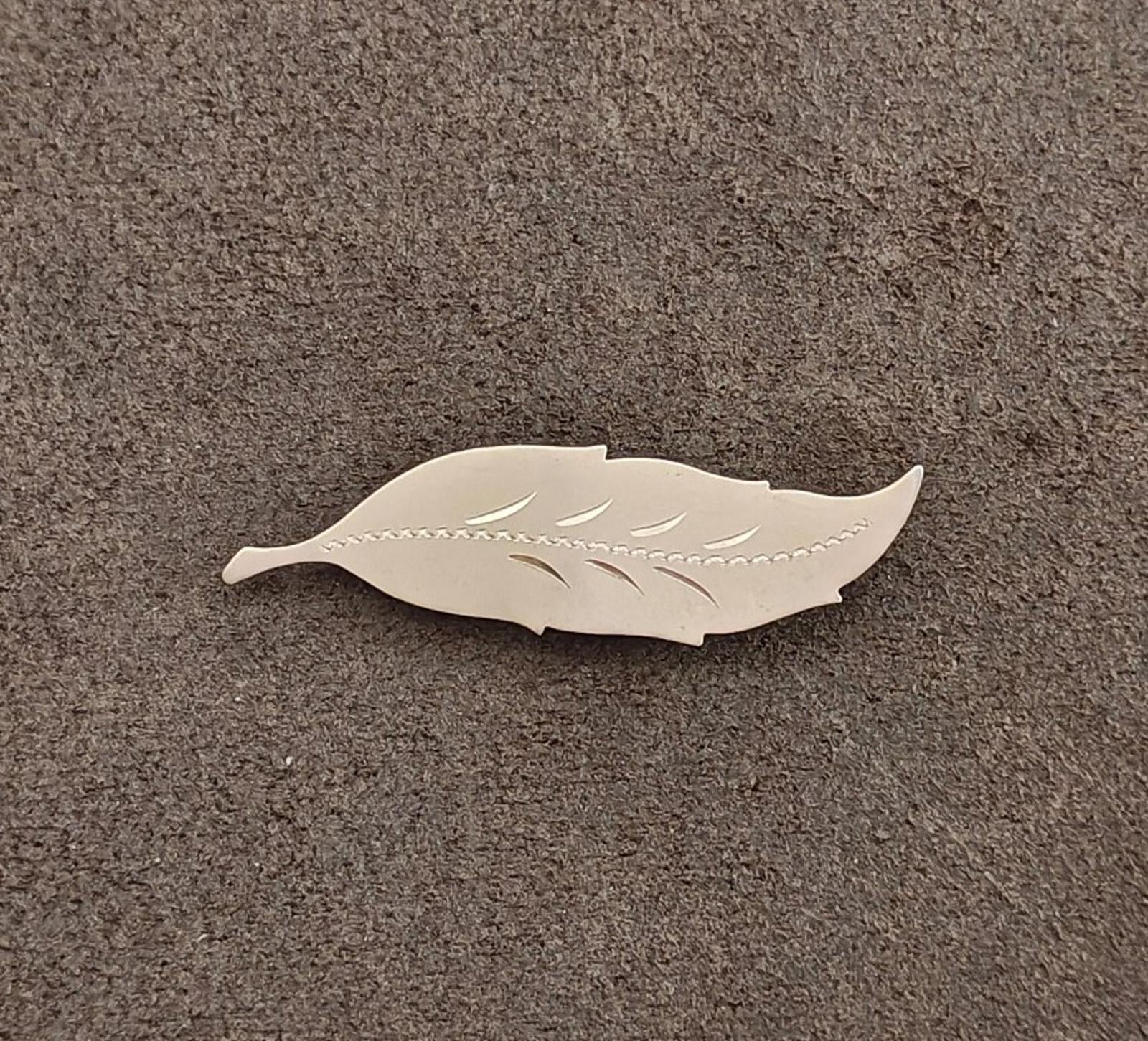 Gold leaf brooch with carved leaf veins and scalloped edge