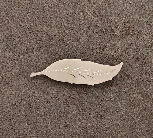 Gold leaf brooch with carved leaf veins and scalloped edge