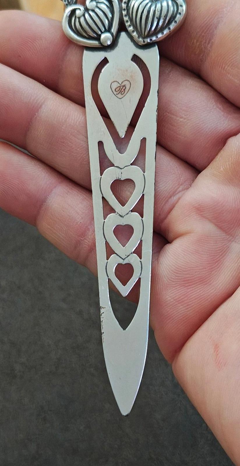 Silver plated letter opener bookmark with vertical row of heart cutouts, pointed tip