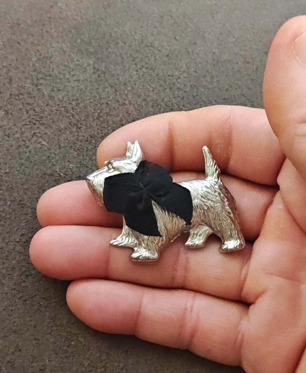 Silver-tone terrier brooch with black bow and detailed face