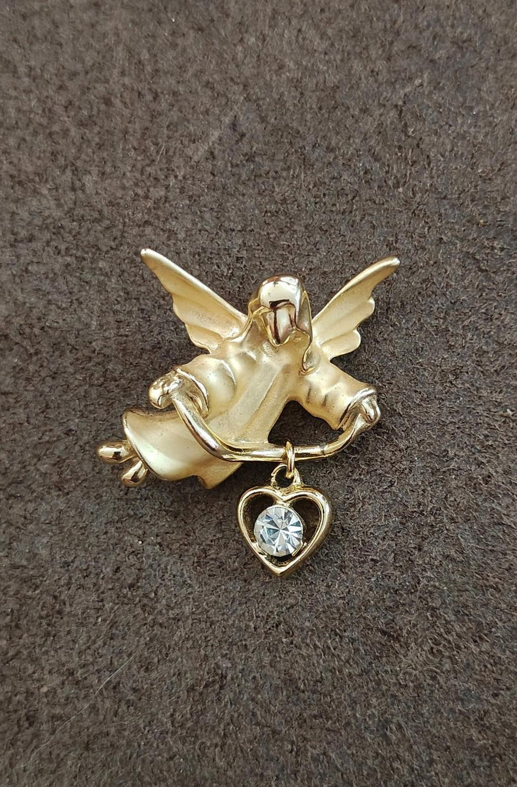 Gold-tone angel brooch pin with hanging heart charm and light blue crystal stone