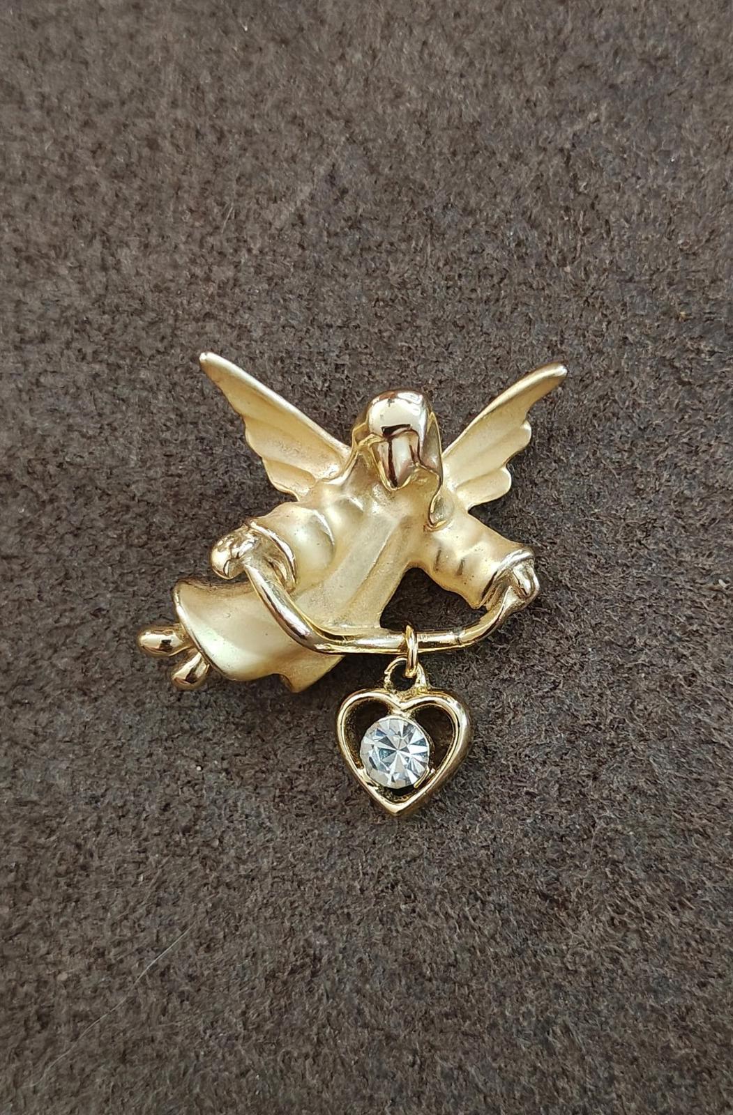 Gold-tone angel brooch pin with hanging heart charm and light blue crystal stone