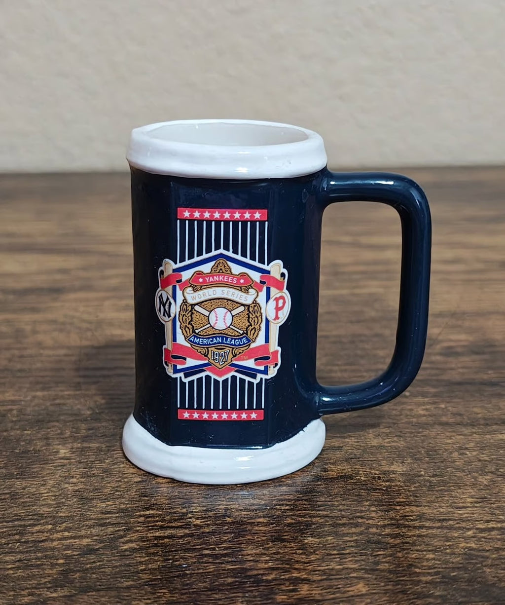 Blue decorative miniature mug with Yankees League patch and curved handle, front view