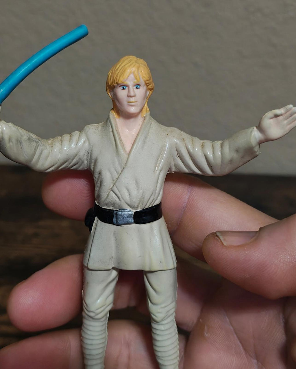Bendable Luke Skywalker action figure with arms outstretched and blue lightsaber