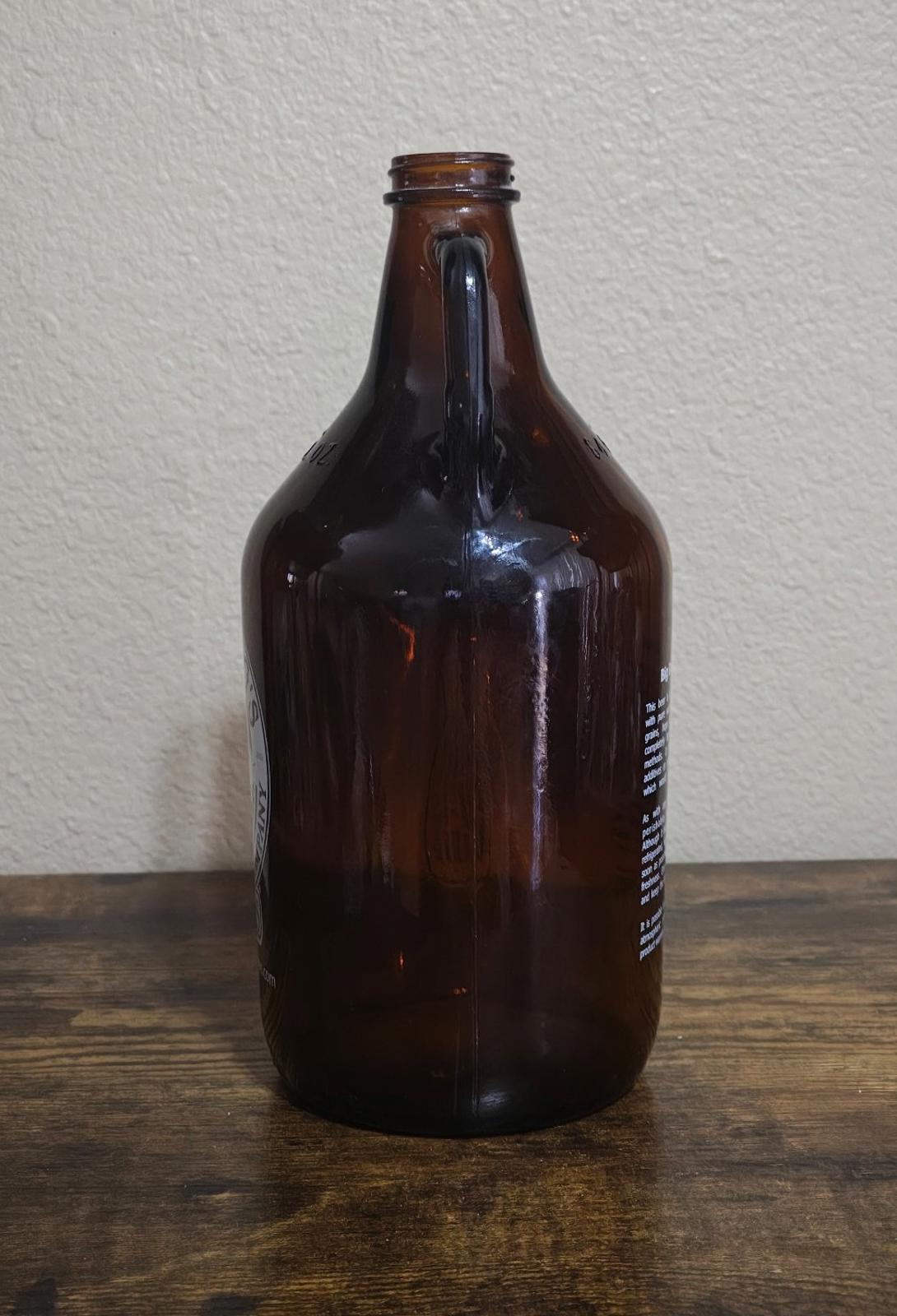 Amber glass jug with short neck and vertical side text