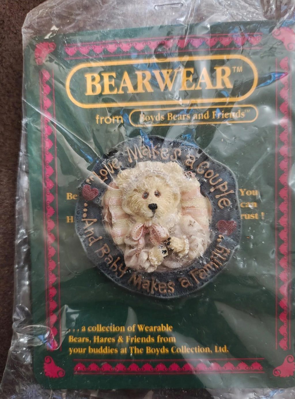 Beige teddy bear brooch in Bearwear packaging, close view of round badge