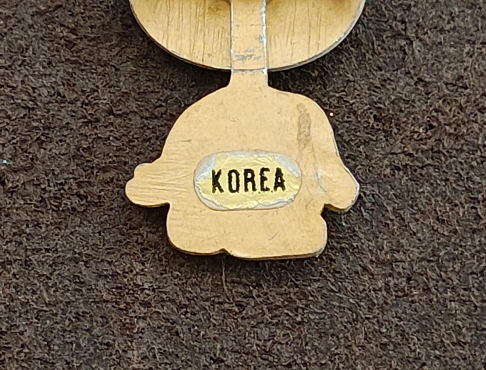 Back of yellow enamel teddy bear brooch with 'KOREA' stamped on the body