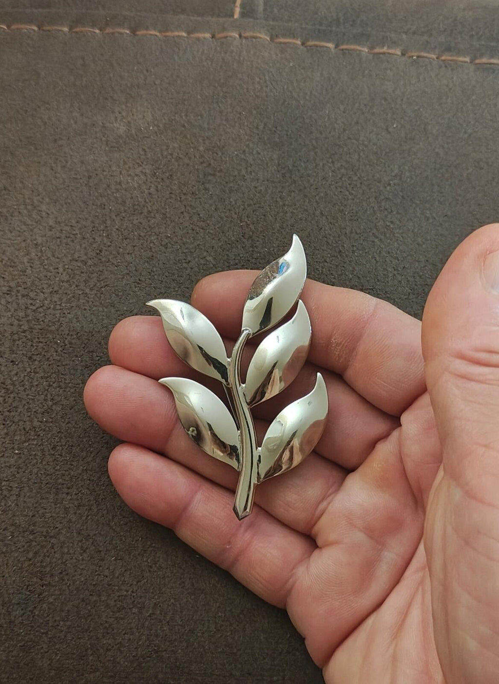 Silver tone modern leaf brooch, five leaves with reflective blue iridescent accents.