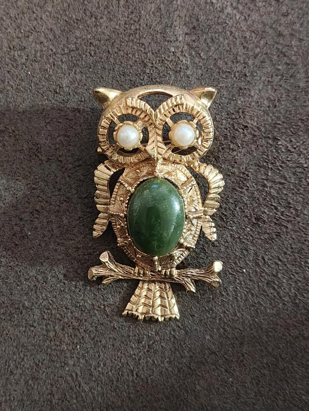 Gold-tone owl brooch with green oval center stone and faux pearl eyes; ornate frame