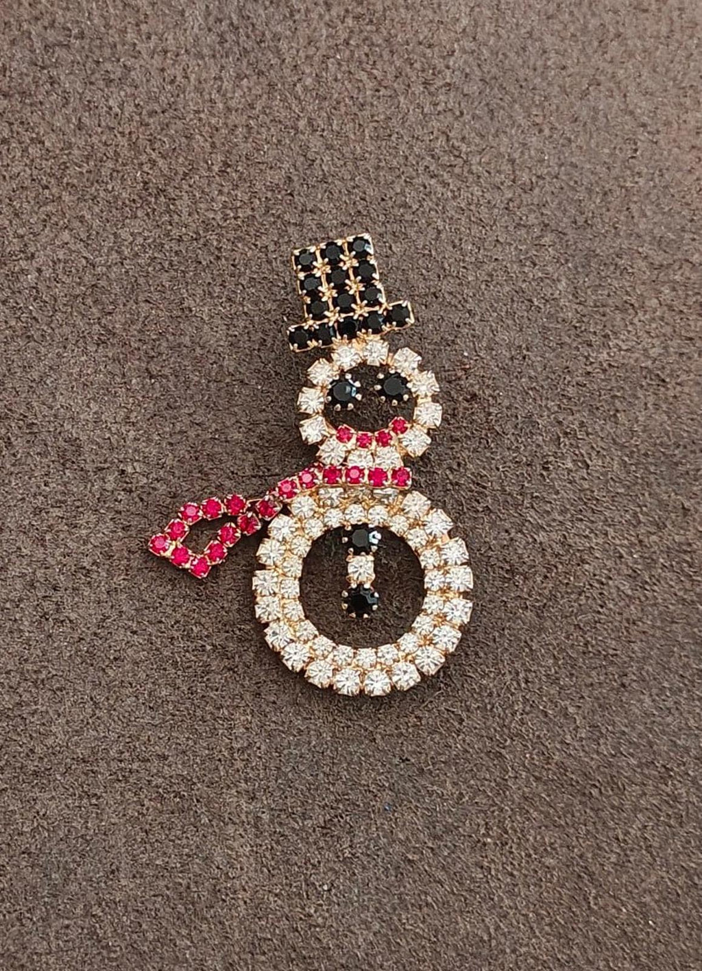 Rhinestone snowman brooch on dark fabric, gold-tone with black, red and clear stones