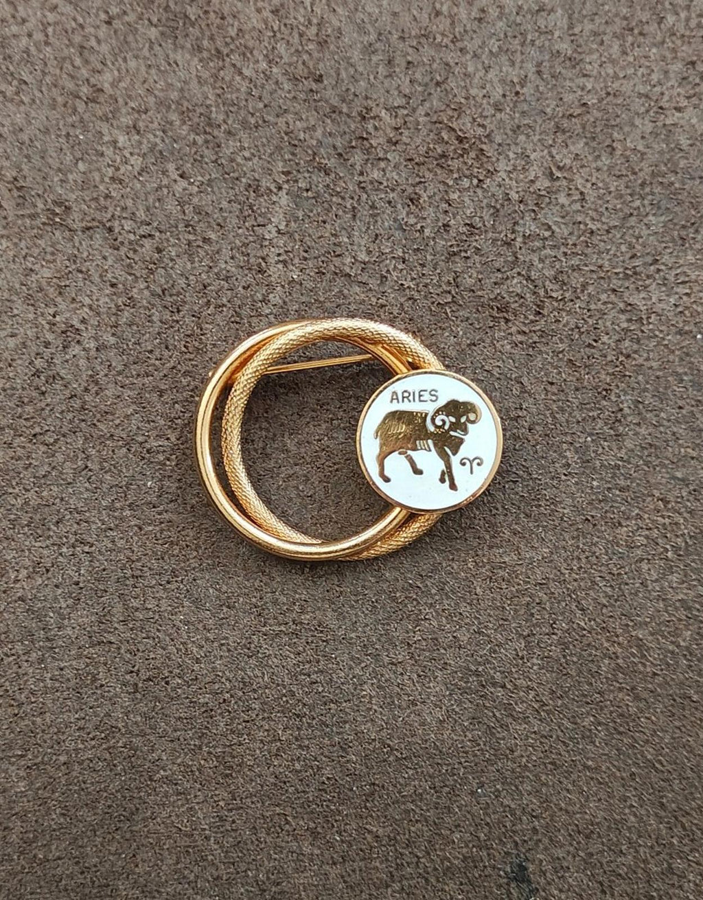 Gold tone circular Aries zodiac brooch pin with white enamel medallion front view