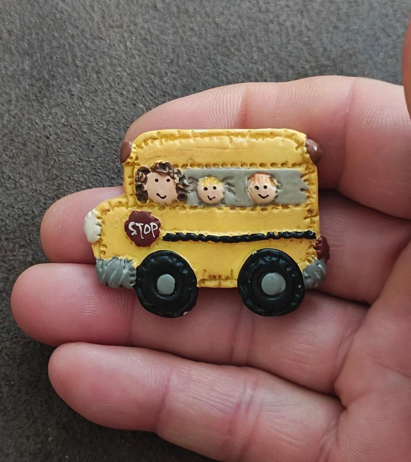Yellow school bus resin pin angled view with cartoon kids and red STOP sign
