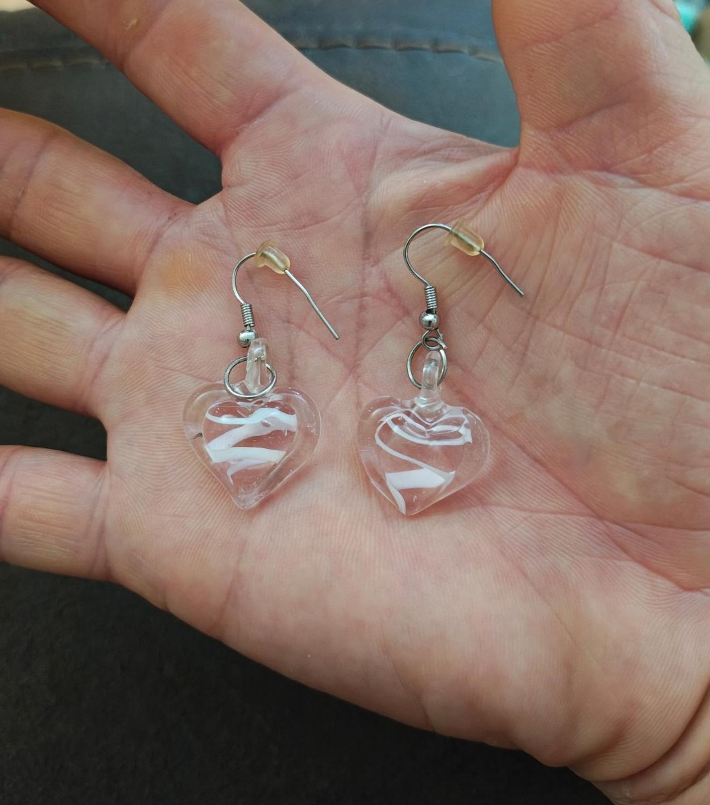 Pair of heart-shaped glass earrings with swirl detail and silver-tone hooks.