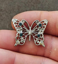 Silver-tone butterfly brooch with clear and blue rhinestones on ornate wings