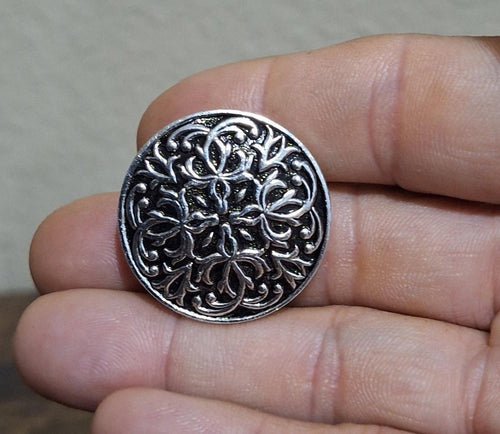 Round silver scarf clip with ornate floral filigree texture