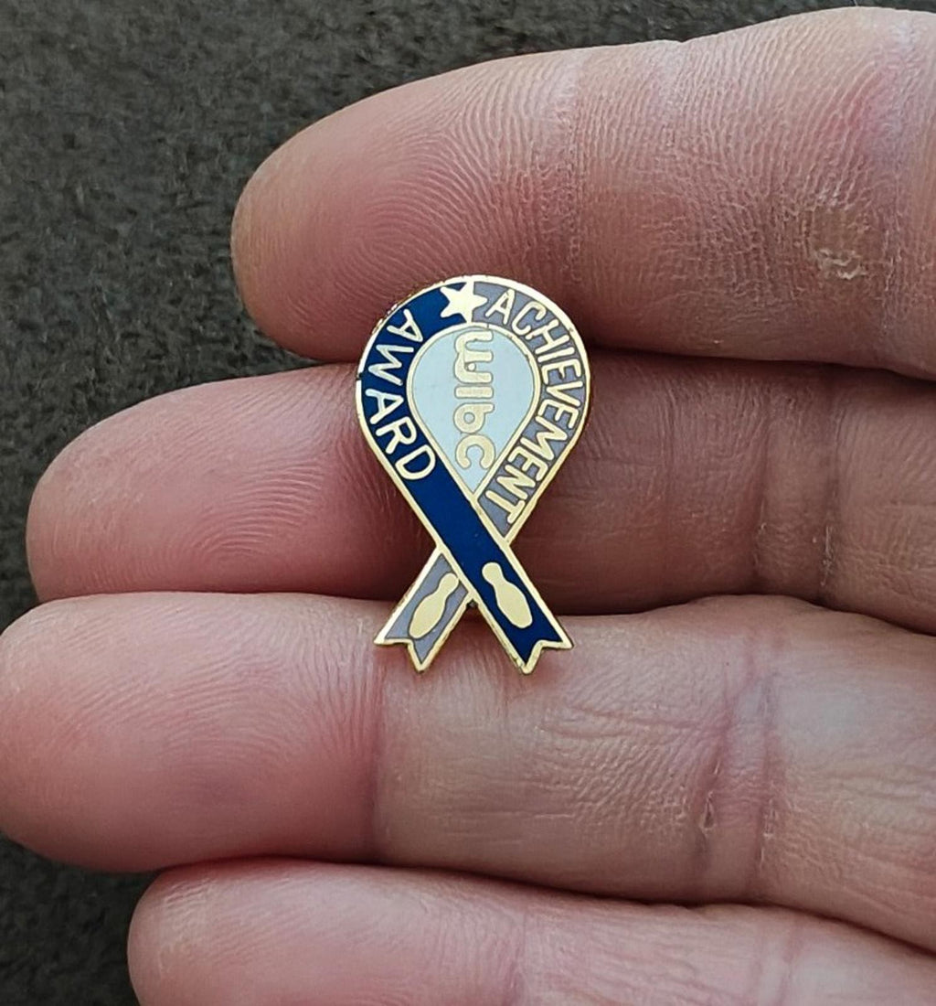 Enamel award pin on blue ribbon design with gold border and circular lettering