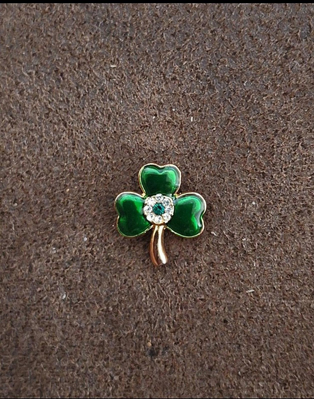 Small green three-leaf clover pin with white rhinestone center and gold-tone stem