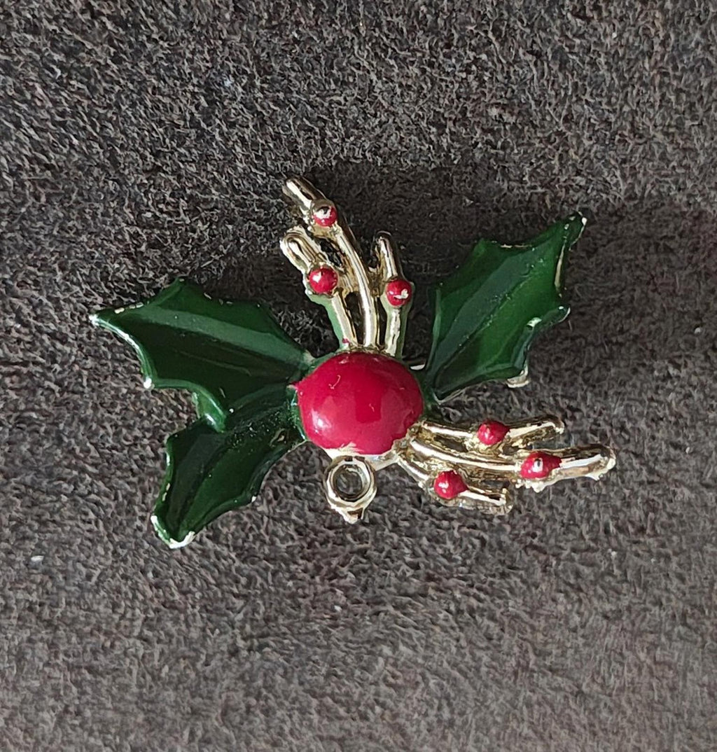 Holly enamel brooch pin featuring green leaves, red berry, and gold-tone branch accents