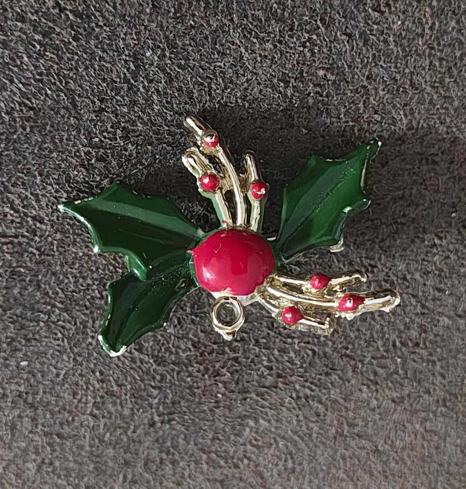 Holly enamel brooch pin featuring green leaves, red berry, and gold-tone branch accents