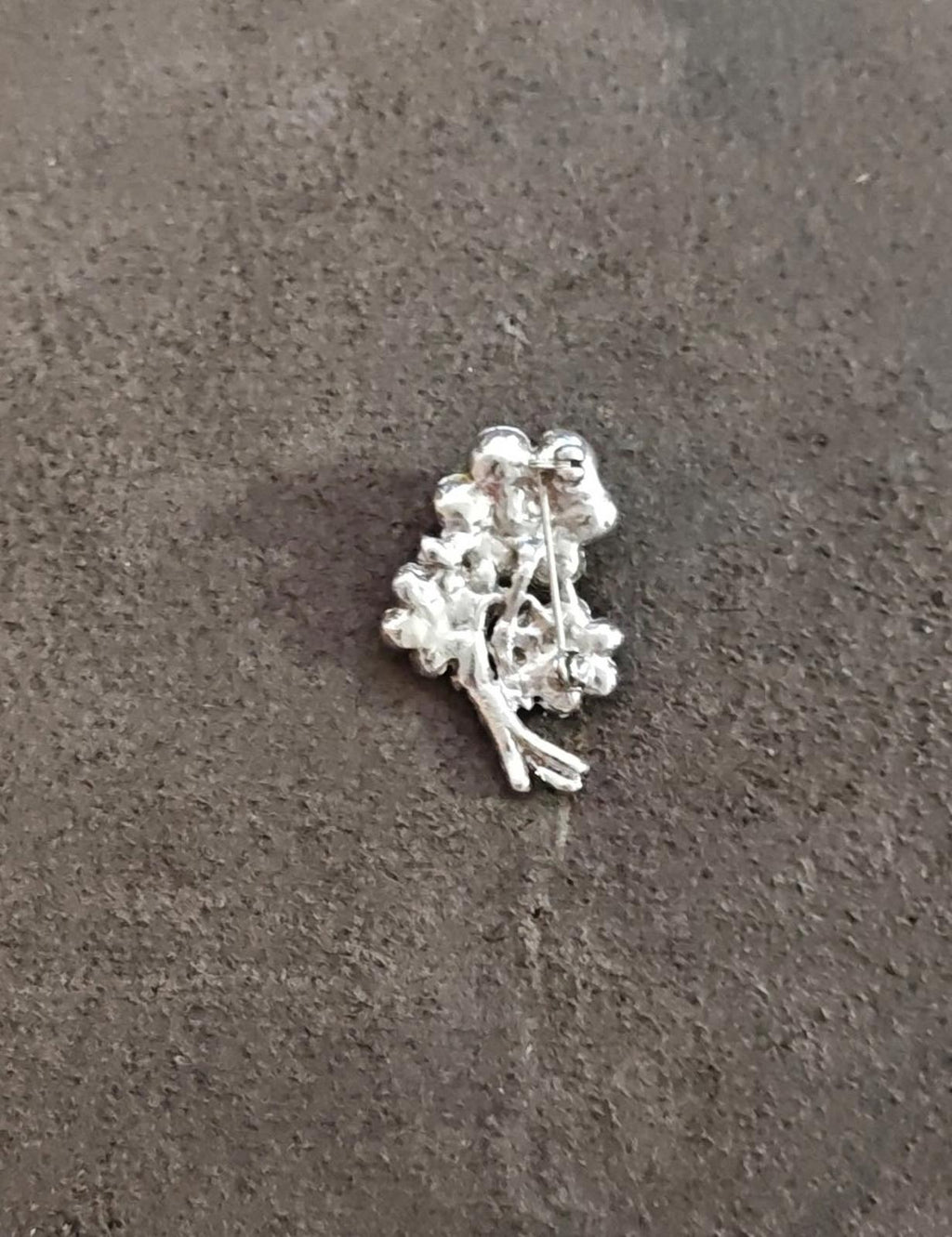 Silver-tone rhinestone flower bouquet brooch with bright clear round stones and curved stem detail