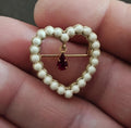 Gold-tone heart brooch with white faux pearls and a red teardrop rhinestone drop