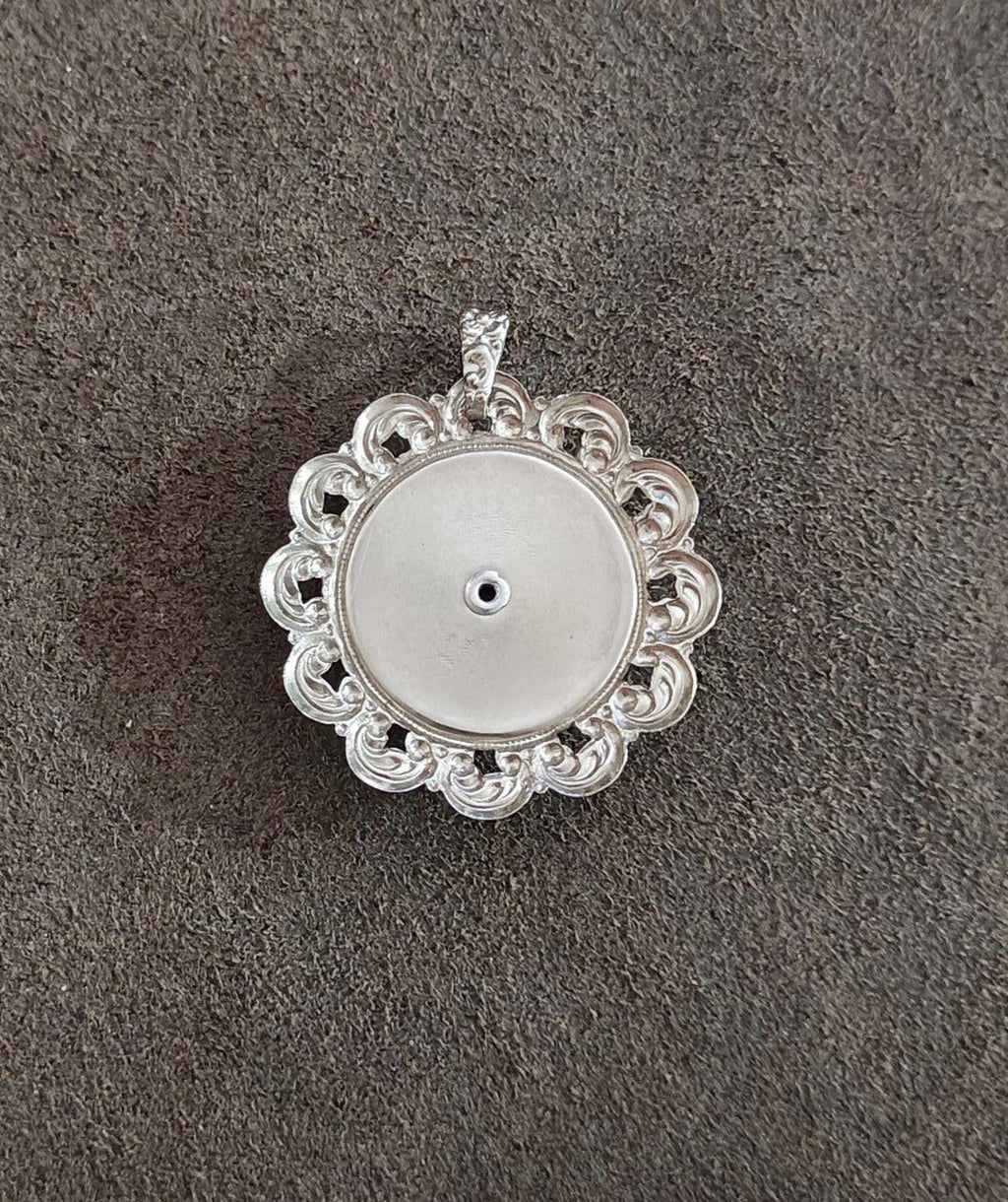 Silver filigree pendant back with circular metal plate and small center hole.
