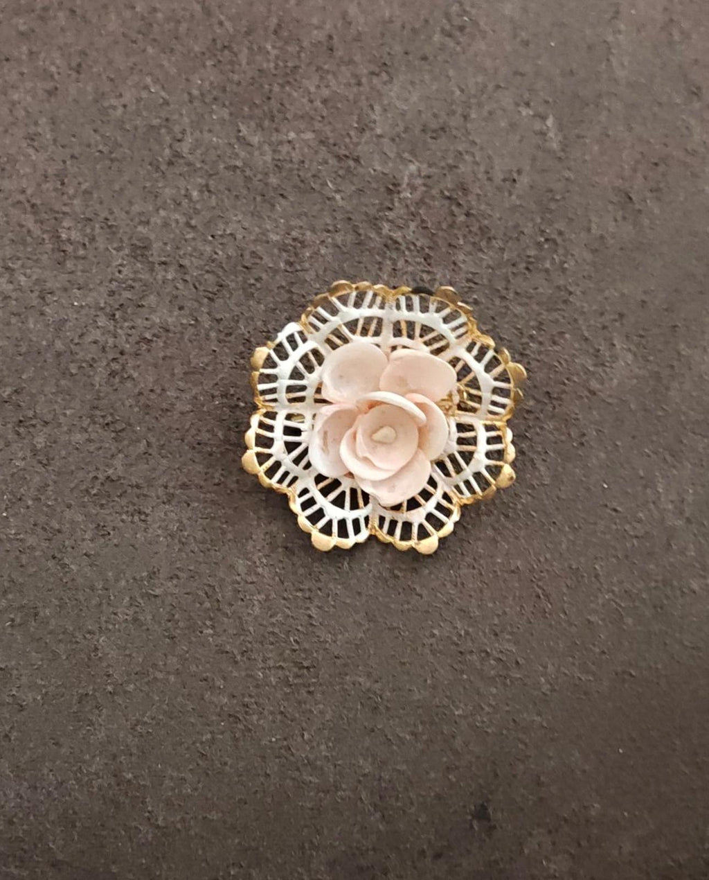 Gold-tone filigree rose brooch shown whole, round openwork frame