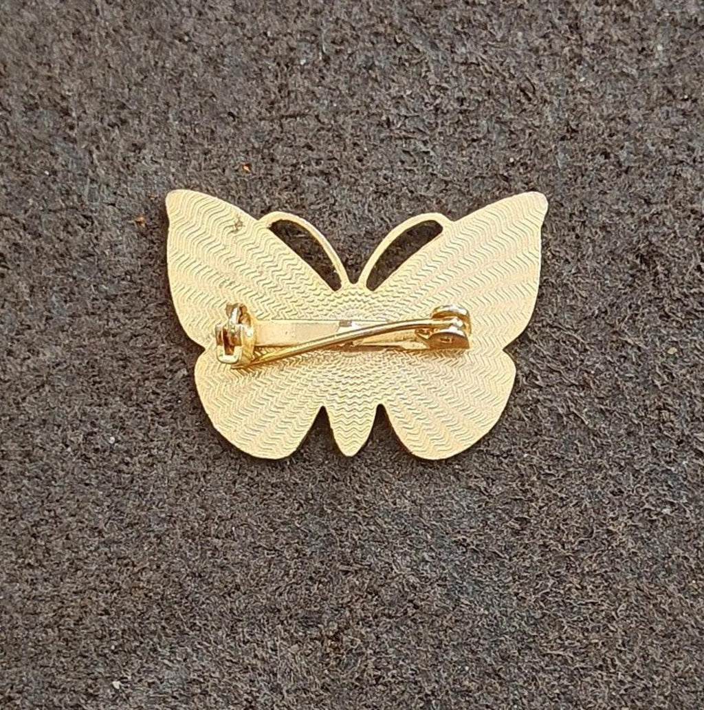 Gold-tone butterfly brooch back with clasp and pin, smooth metal finish.