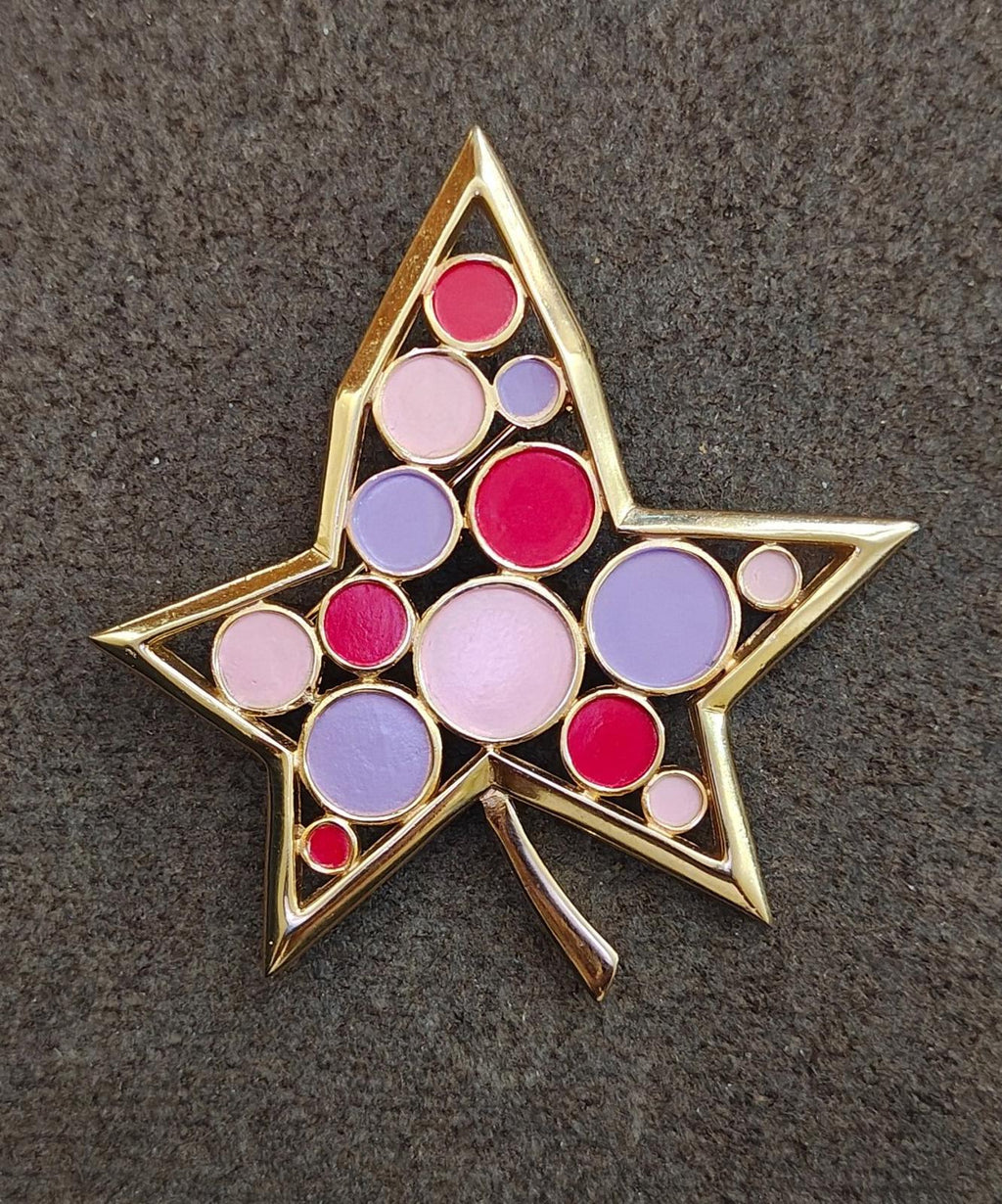 Crown Trifari gold star brooch with red, purple, and pink round enamel cabochons