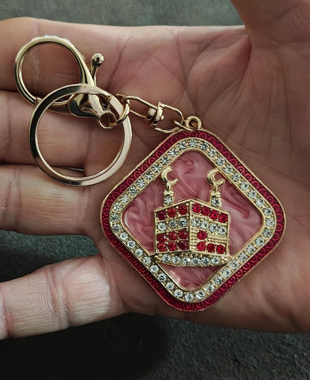 Gold-tone keychain with pink crown pendant, red border, clear and red rhinestone trim