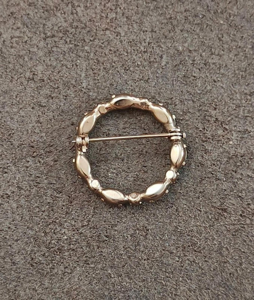 Gold-tone round brooch back with bar pin and small raised detail on inner circle