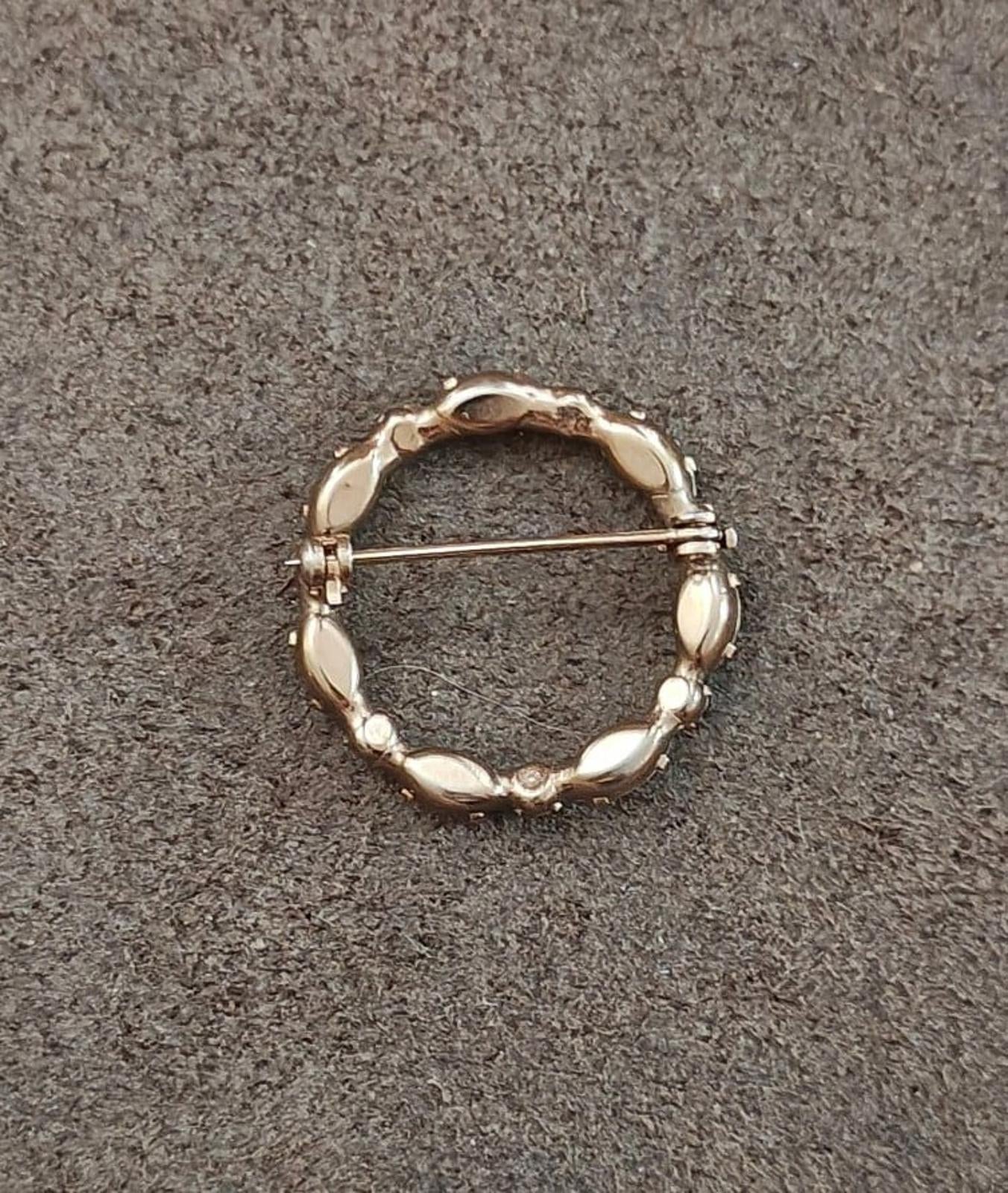 Gold-tone round brooch back with bar pin and small raised detail on inner circle
