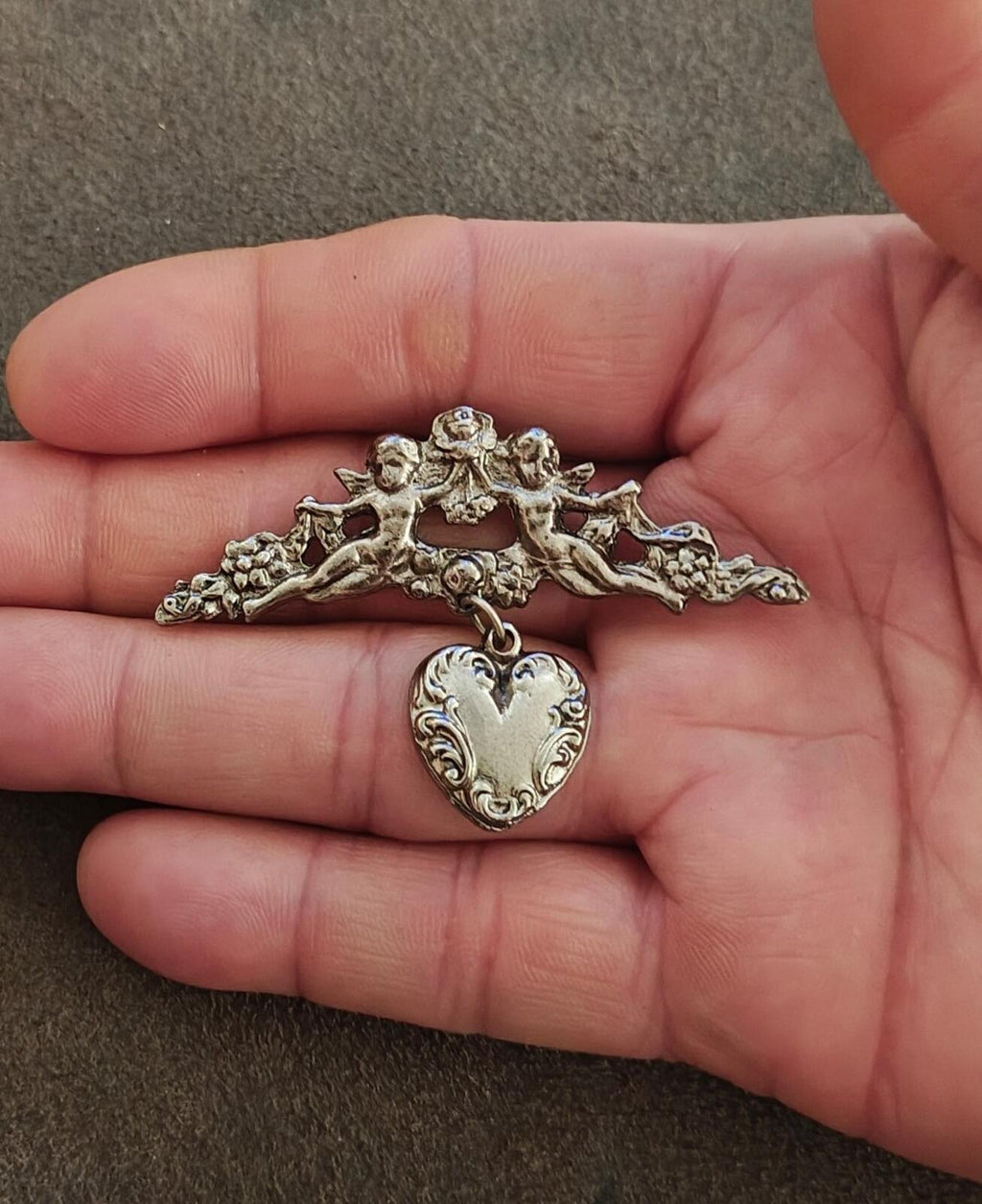 1980s Silver Tone Renaissance Style Cherub Brooch With Dangling Heart Charm