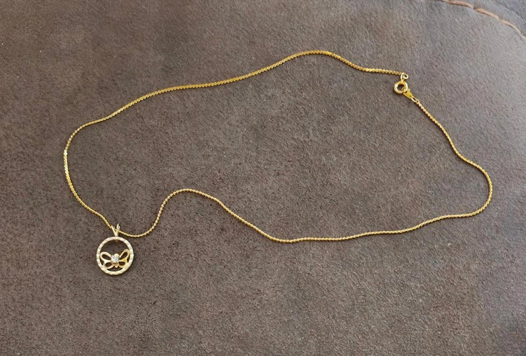 Gold-tone chain necklace with round butterfly pendant and small matching charm at end