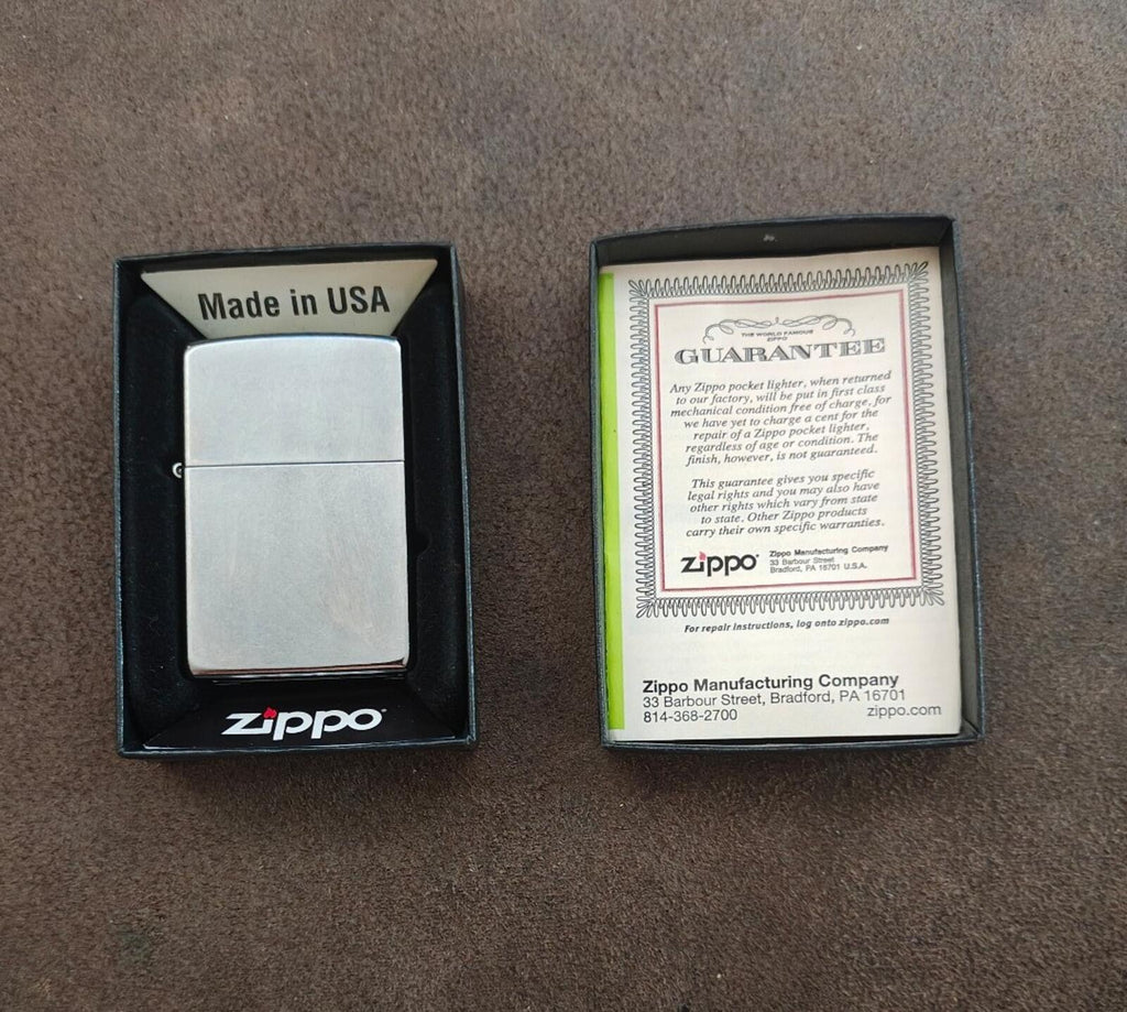 Silver Zippo windproof lighter with warranty card in black presentation box.