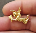 Gold tone flying angel brooch, angel holding small flowers