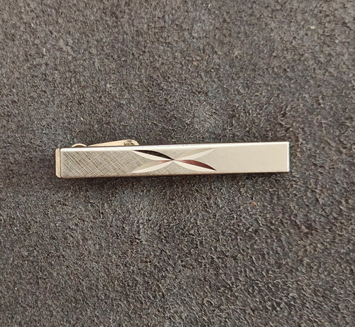 Gold-tone tie bar/clip featuring a diamond-cut atomic starburst design