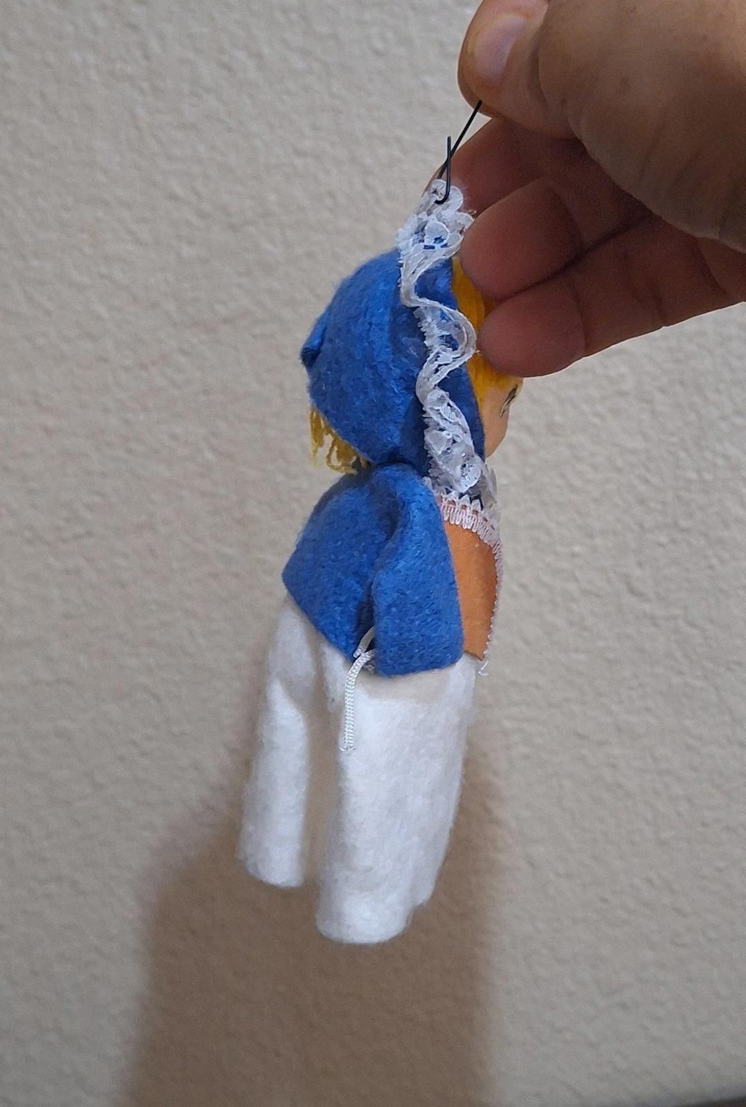 Handmade pilgrim girl ornament figurine angled view, blue sleeves and white apron
