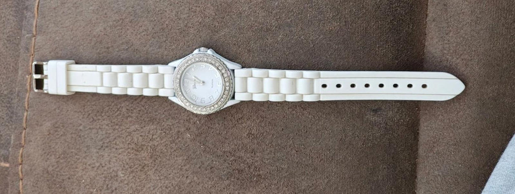 White silicone strap wristwatch with rhinestone bezel and silver-tone case, side view